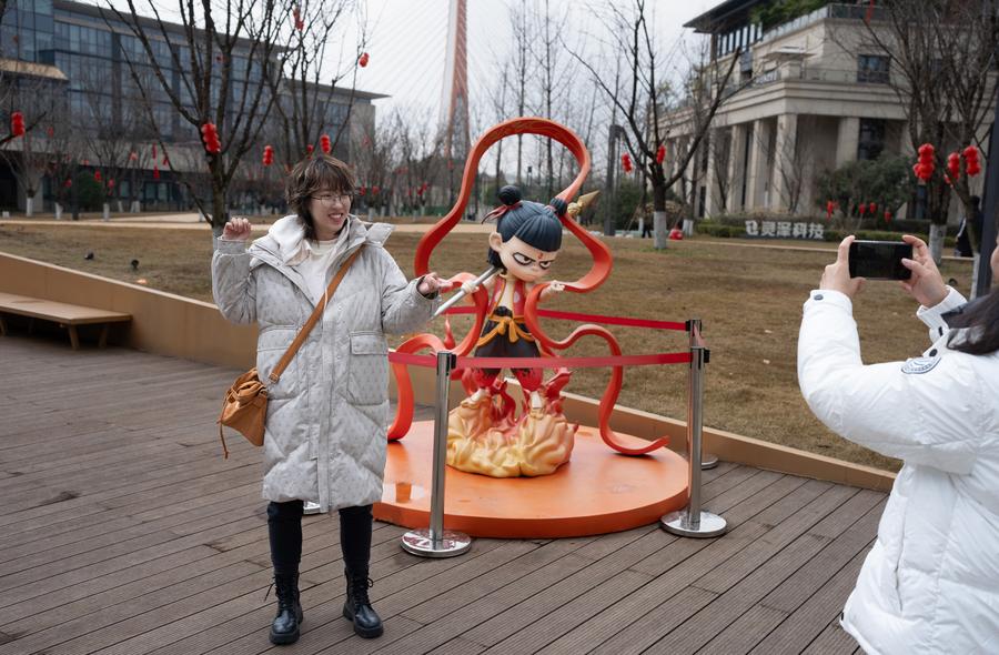Une fan pose devant une statue de Nezha, le personnage principal de "Ne Zha 2", &agrave; la Gazelle Digital Cultural and Creative Valley &agrave; Chengdu, dans la province du Sichuan, dans le sud-ouest de la Chine, le 8 f&eacute;vrier 2025. (Photo : Jiang Hongjing)